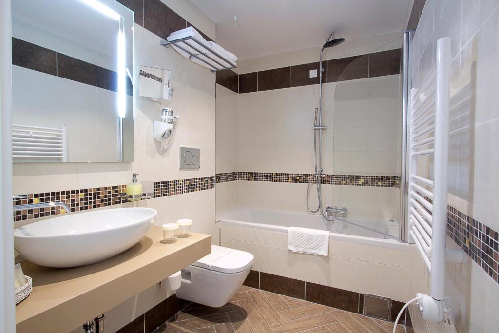 Mūsdienīga vannas istaba ar peldošu izlietni, vannu un dušas kabīni, elegantām flīzēm un labiekārtotu interjeru. Ideāla vieta relaksācijai un komfortam.