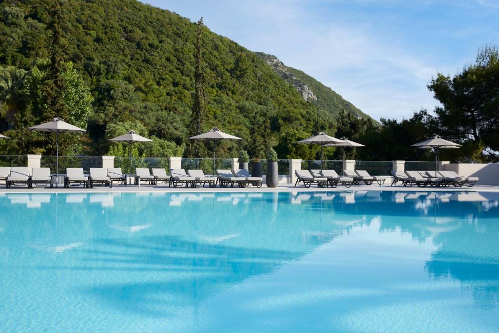 Peldbaseins ar saulessargiem un sauļošanās krēsliem, ko ieskauj zaļi kalni un skaidrs debesis. Ideāla vieta relaksācijai un atpūtai.