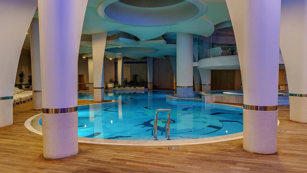 Moderns iekštelpu peldbaseins ar stilīgām kolonnām un relaksējošu apgaismojumu, radot mierīgu atmosfēru. Ideāla vieta atpūtai un relaksācijai.