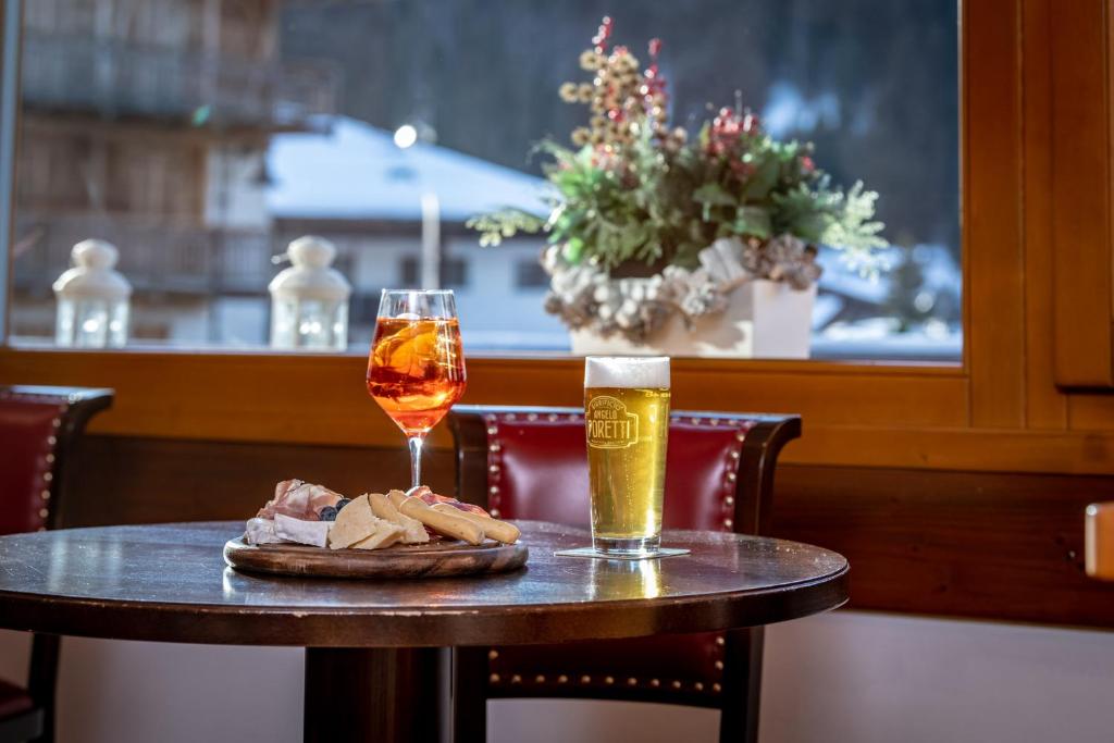 Galda apakšā ir apkalpošana ar alus glāzi un dzērienu ar augļiem, blakus atrodas šķīvis ar uzkodām. Logā redzams ziemas ainava ar zaļo augšanu.