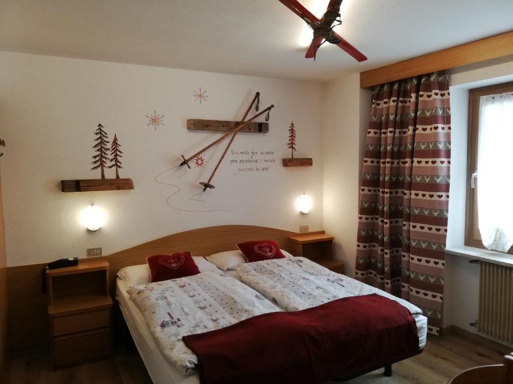 Mūsdienīgs guļamistabas interjers ar kalnu tematiku, tostarp koka dekori un silti toņi. Gultas ar sarkanām sega un interesantiem aizkariem, kas piešķir mājīgu atmosfēru.