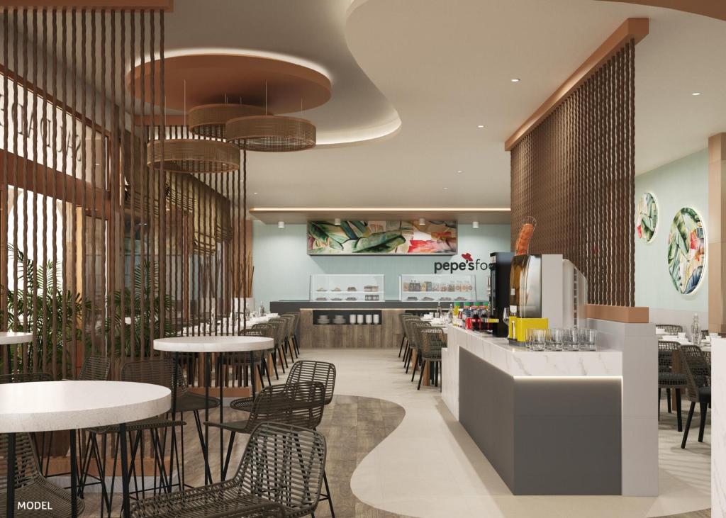 Mūsdienīga restorāna interjers ar stilīgām mēbelēm, apgaismojumu un dekoratīvām augu kompozīcijām, radot patīkamu atmosfēru. Atvērta virtuve un bāra zona piedāvā plašu dzērienu klāstu.