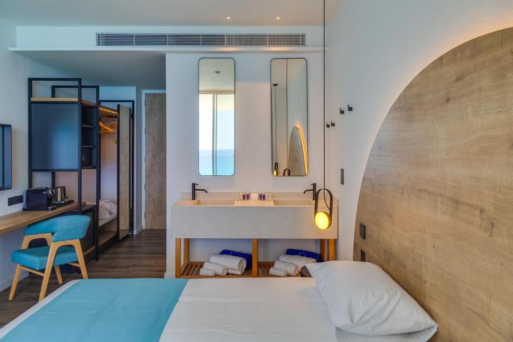 Mūsdienīgs viesnīcas numurs ar koka akcentiem, elegantu vannas istabu un skatu uz jūru. Istabā ir ērtas mēbeles un stilīgs apgaismojums.