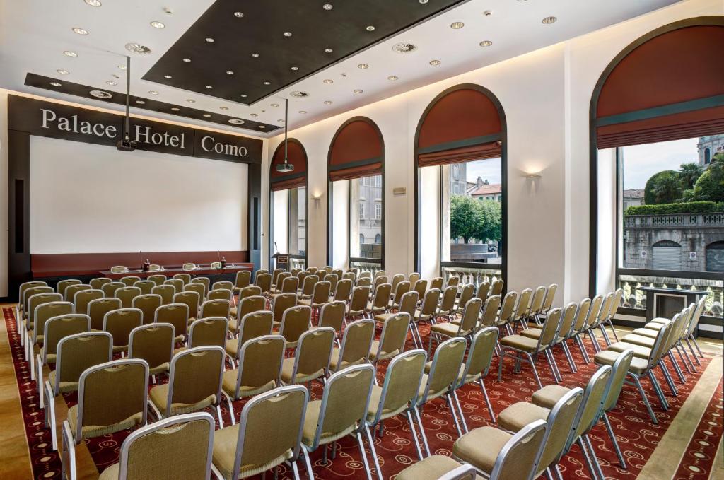 Konferenču zāle ar sēdvietām, kas gaida apmeklētājus, atrodas Palace Hotel Como, piedāvājot modernu un elegantu vidi. Lieli logi nodrošina dabisku apgaismojumu un skatu uz apkārtni.