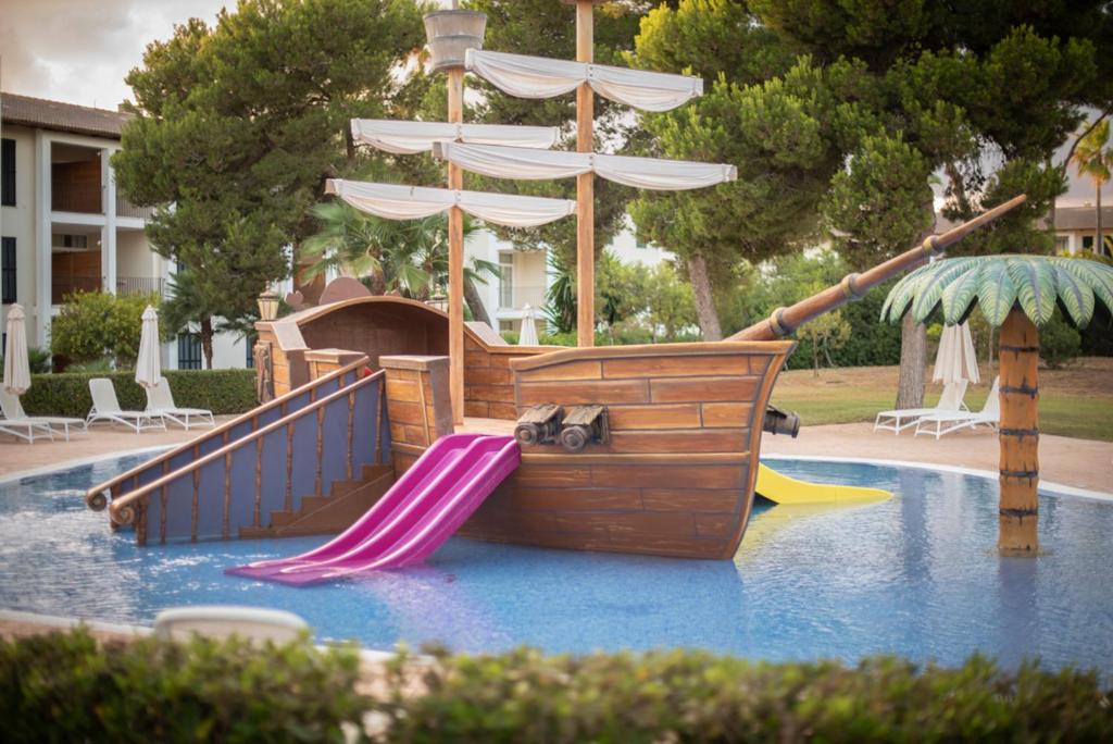 Bērnu ūdens atrakciju laiva ar slidkalniņu un palmu, izvietota peldbaseinā. Ideāla vieta bērniem, lai pavadītu laiku un izklaidētos.