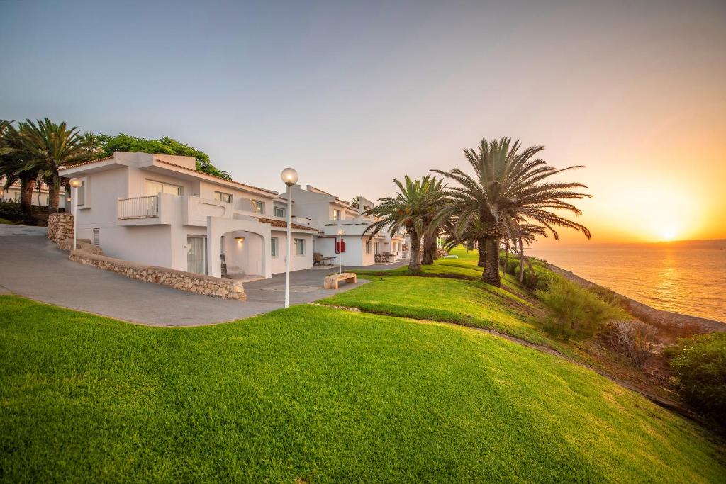 Mūsdienīga pludmales māja ar palmu ainavu un saulrietu. Ideāla vieta relaksācijai pie jūras.