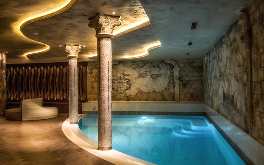 Elegants un mūsdienīgs spa interjers ar peldbaseinu un greznām kolonnām, izceltām ar maigu apgaismojumu un mākslinieciskām sienām. Ideāla vieta relaksācijai un atpūtai.