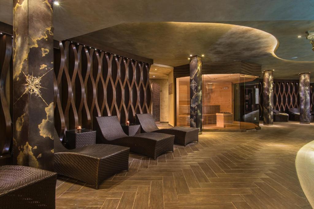 Luksusa spa iekārtojums ar ērtām atpūtas krēslām un elegantu apgaismojumu, radot relaksējošu atmosfēru. Interjerā dominē tumši toņi un mūsdienīgas formas.