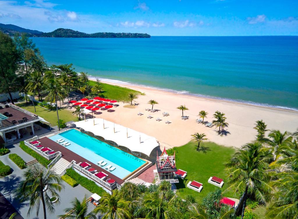 Angsana Laguna Phuket baseins piekrastē ar sarkaniem sauleskrēsliem