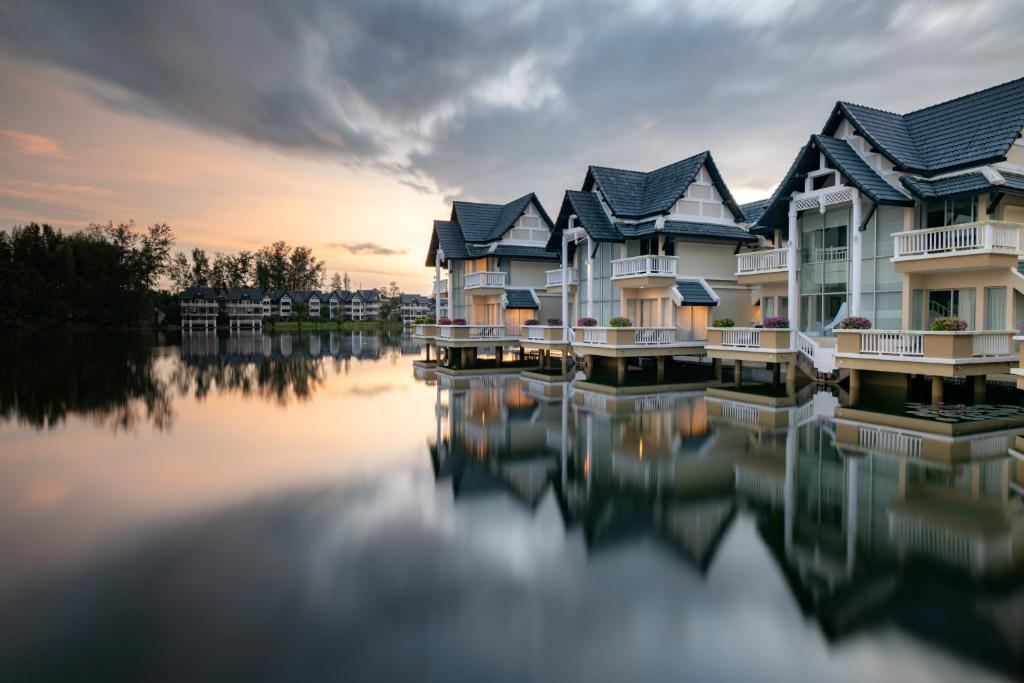 Villas piekrastē, Angsana Laguna Phuket, atspoguļojas mierīgā ūdenī.