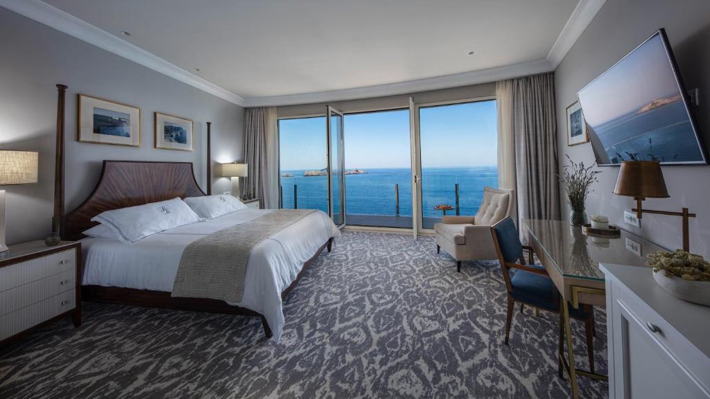 Luksusa viesnīcas numurs ar skatu uz jūru, iekārtots ar modernām mēbelēm un ērtu gultu. Lielie logi nodrošina daudz gaismas un brīnišķīgu skatu.