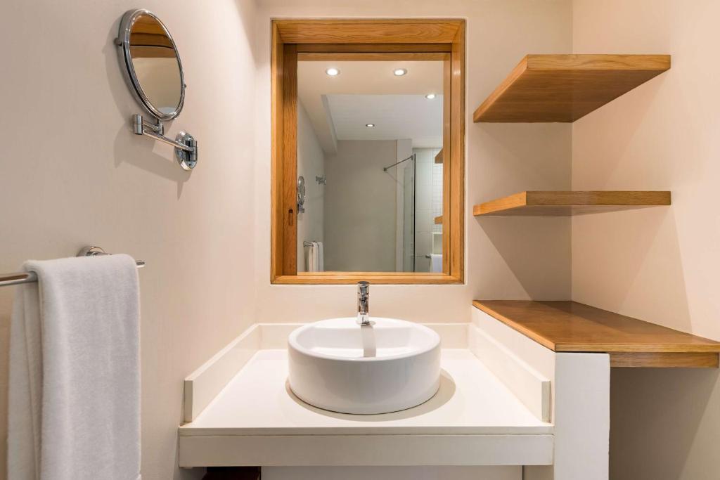 Mūsdienīgs vannas istabas skats ar baltu izlietni Radisson Blu Poste Lafayette Resort & SPA