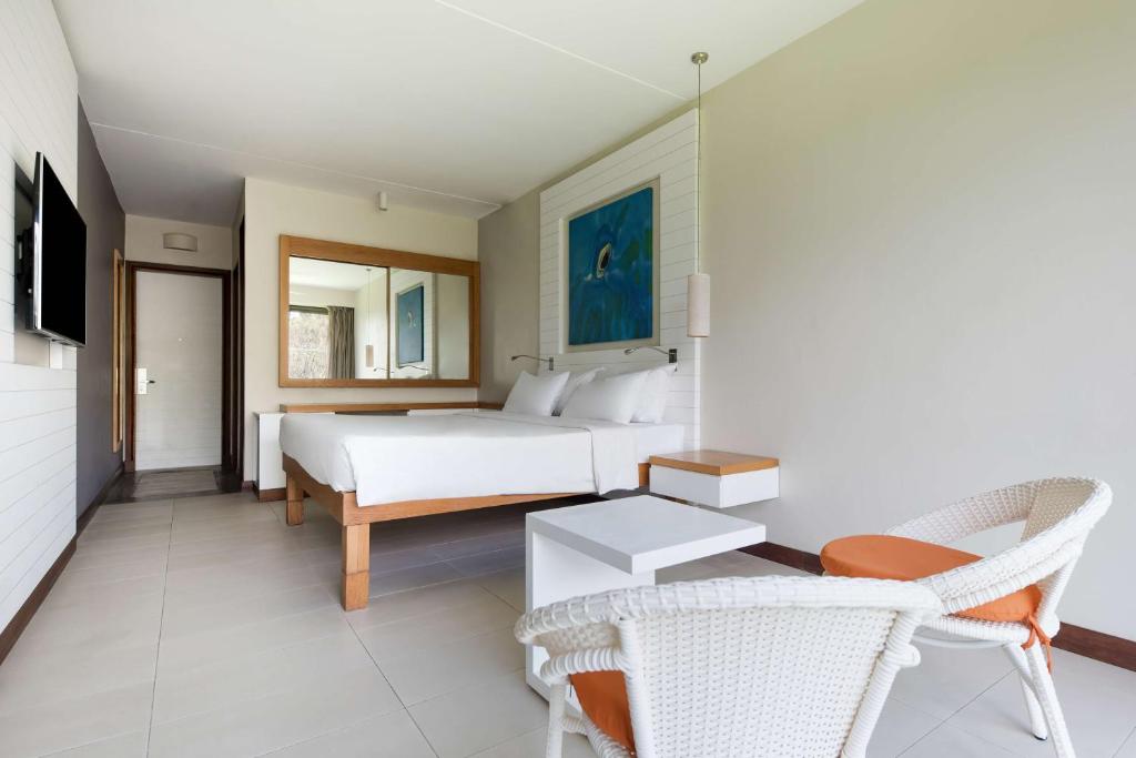 Moderns numurs Radisson Blu Poste Lafayette Resort & SPA ar gultu un sēdvietām.