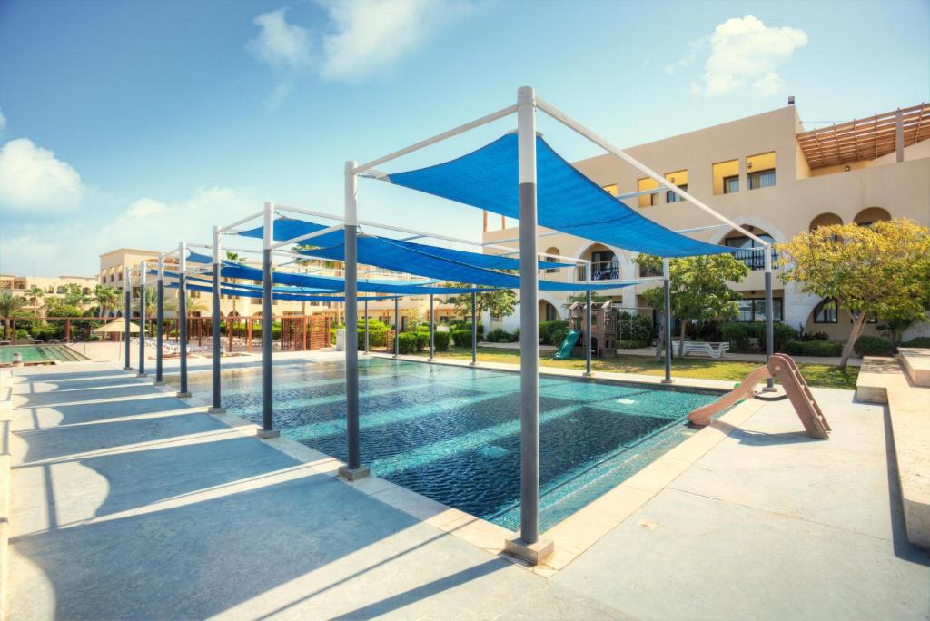 Baseina zona ar zilu nojumi, kas nodrošina ēnu, un tuvumā esošām viesnīcas ēkām. Lielisks atpūtas un izklaides vieta ģimenēm.