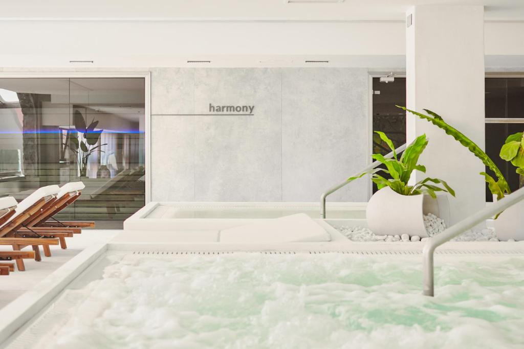 Mūsdienīgs spa ar relaksējošu atmosfēru, kurā redzami masāžas krēsli un zaļi augi. Ideāla vieta atpūtai un harmonijai.