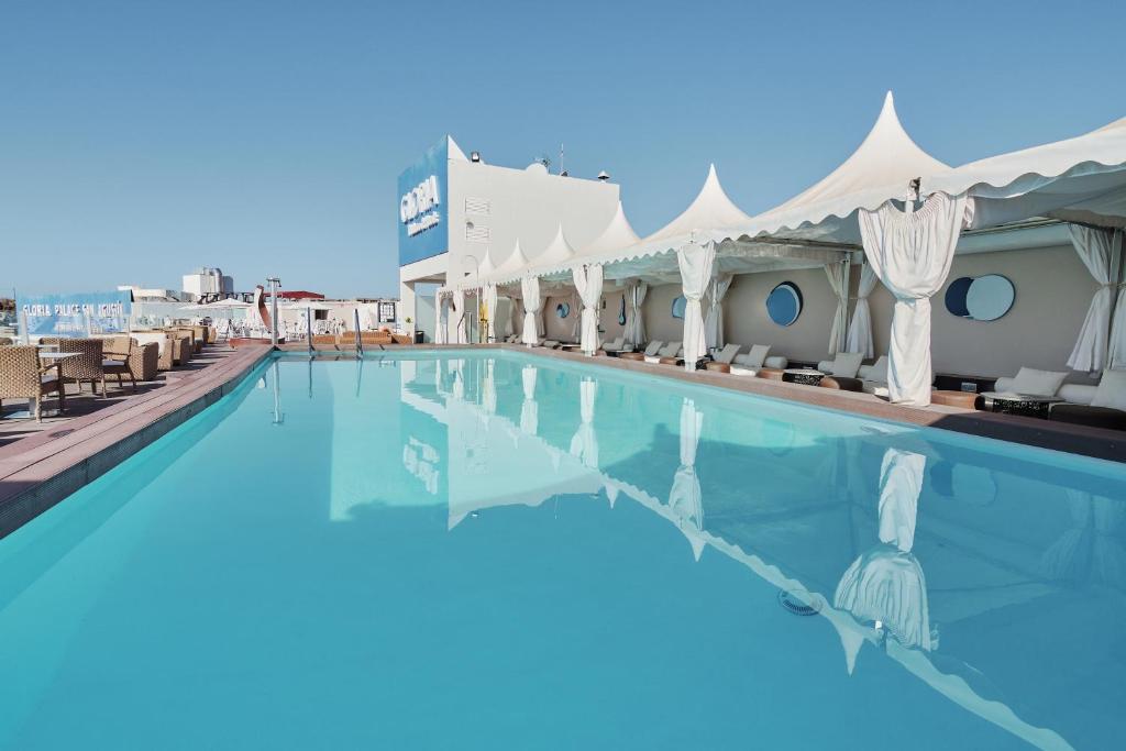 Peldbaseins ar dzidru ūdeni un atpūtas zonu, ieskauj balti teltis un moderns dizains. Ideāla vieta relaksācijai un atpūtai saulainā dienā.