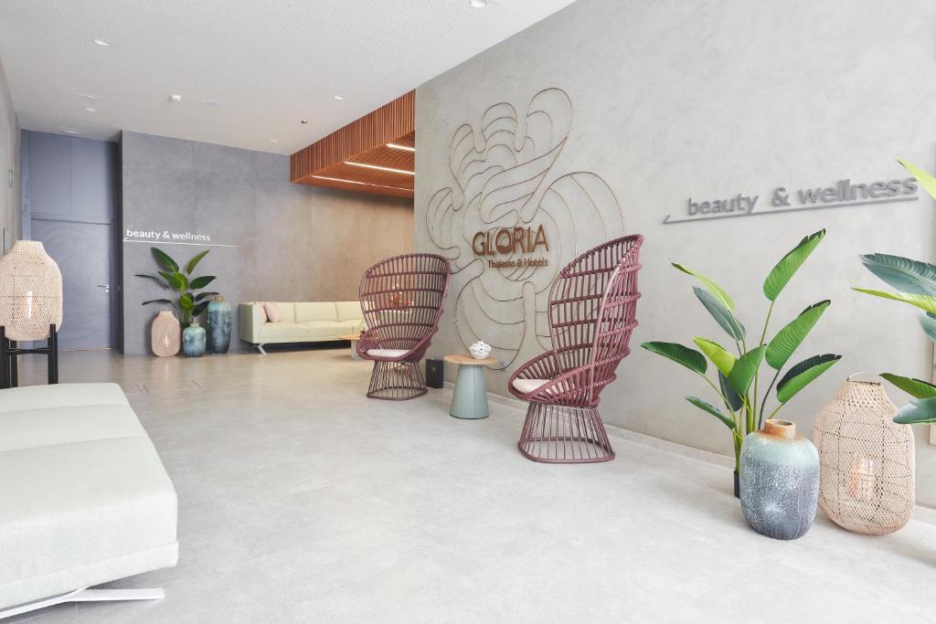 Mūsdienīgs skaistumkopšanas un labklājības salons ar elegantām mēbelēm, augiem un mākslinieciskajiem elementiem, radot relaksējošu atmosfēru.