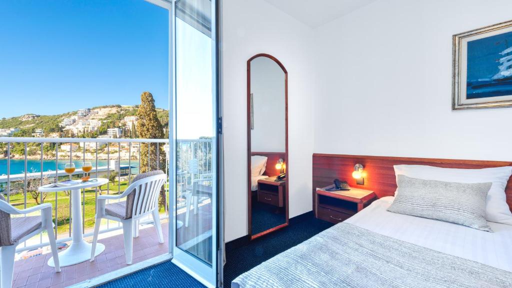 Mūsdienīga viesnīcas numura interjers ar balkonu, no kura paveras skats uz jūru un apkārtējo ainavu, iekārtots ar ērtām mēbelēm un gaismas avotiem.