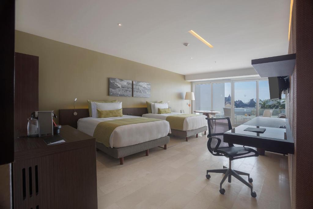 Mūsdienīgs viesnīcas numurs ar divām gultām, rakstāmgaldu un skatu uz ārpusi. Interjers ir gaišs un elegants, ar neitrālām krāsām un komfortablu mēbelējumu.