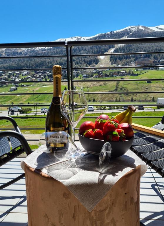 Svaigi augļi un šampanietis uz balkona, ar kalnu ainavu fonā. Ideāla vieta relaksācijai saulainā dienā.