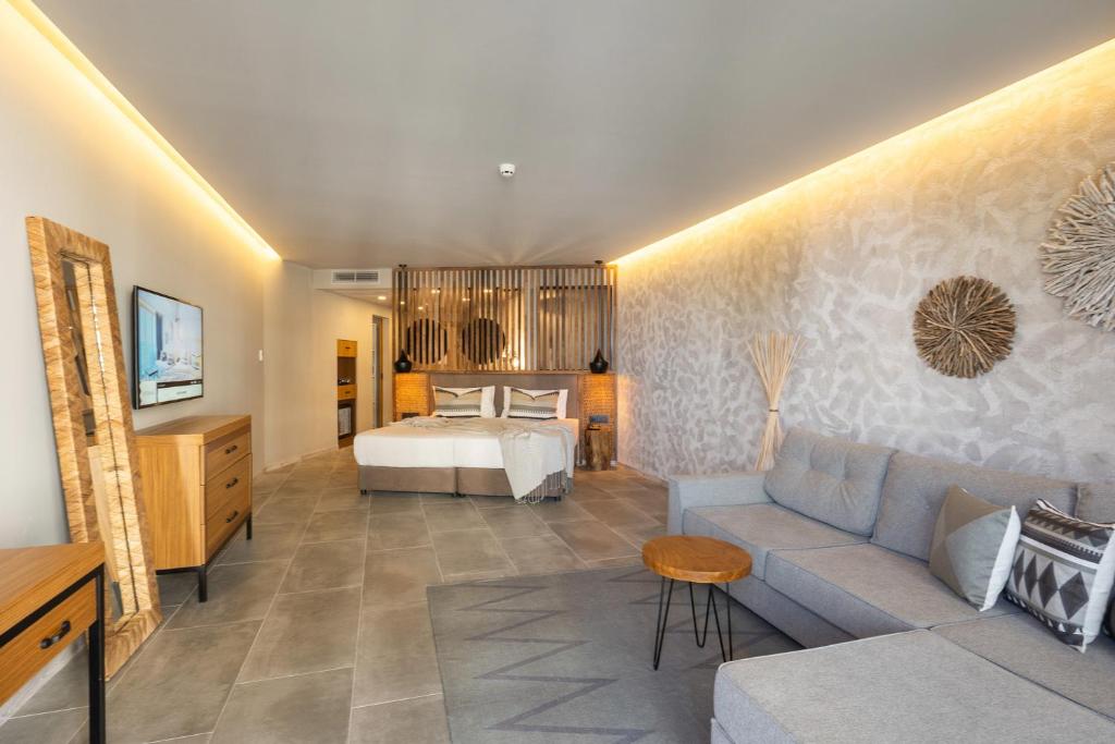 Moderns viesnīcas numurs ar mūsdienīgu interjeru, gultu, dīvānu un ērtībām. Sienas dekorētas ar dabīgām tekstūrām un gaismas elementiem.