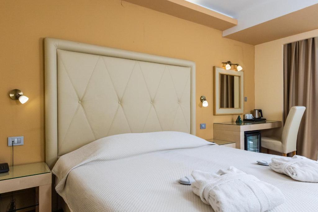 Mūsdienīgs viesnīcas numurs ar dzeltenām sienām, ērtu gultu un modernu rakstāmgaldu. Numurā ir arī spogulis un mini ledusskapis, radot viesmīlīgu atmosfēru.