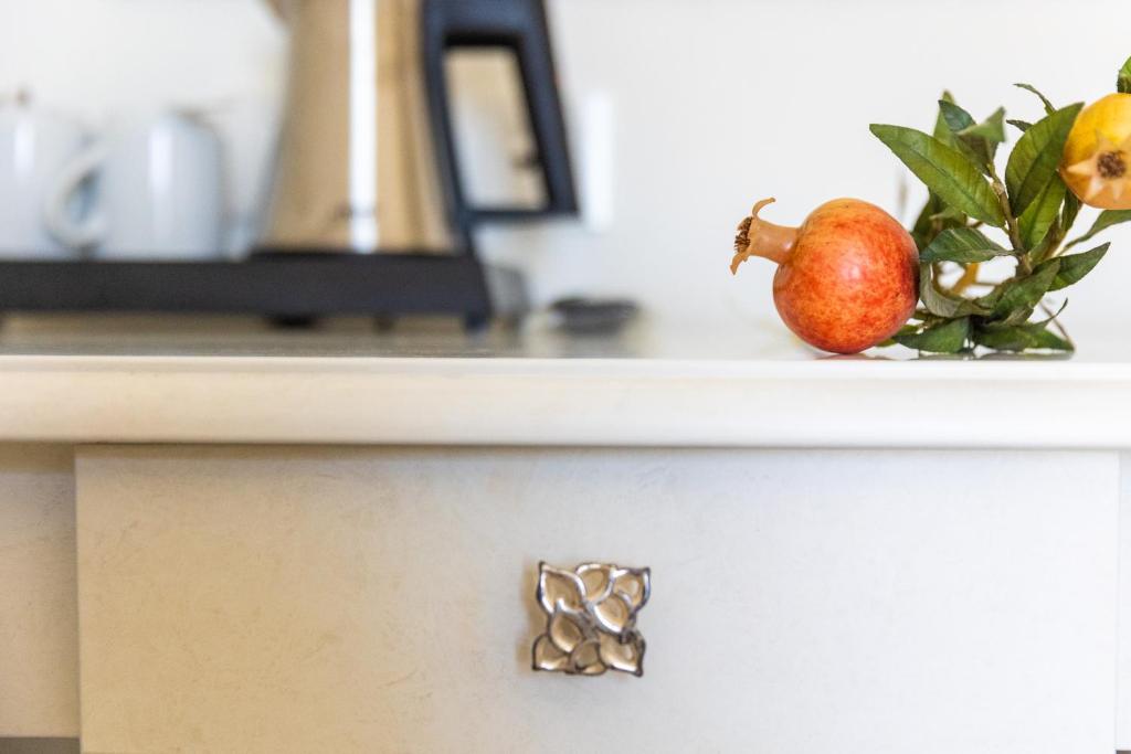 Kafijas automāts un augļu kompozīcija uz virtuves galda, izceļot elegantu interjera dizainu.