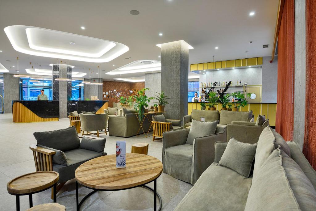 Mūsdienīgs viesnīcas bārs ar komfortablām mēbelēm un augu dekorācijām, radot relaksējošu atmosfēru. Gaismas un interjera dizains veicina patīkamu atpūtu.