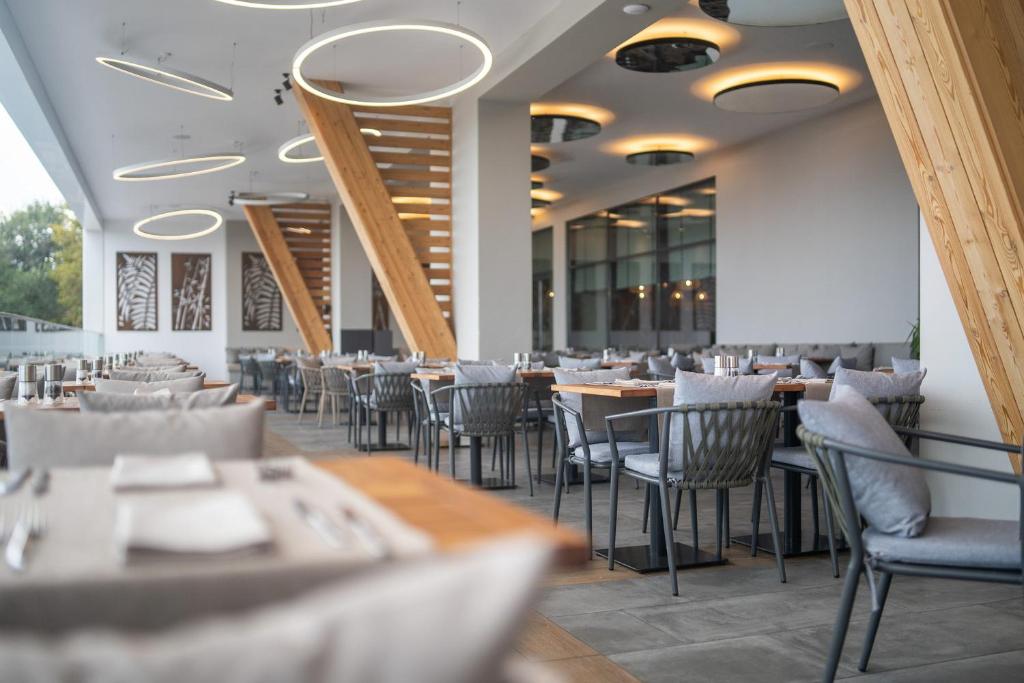 Mūsdienīgs restorāns ar elegantu interjeru, kurā ir koka elementi un mūsdienīgas gaismas instalācijas, piedāvā komfortablas ēdināšanas zonas un izsmalcinātu atmosfēru.