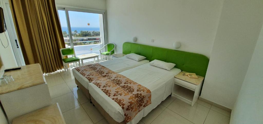 Mūsdienīgs viesnīcas numurs ar divām atsevišķām gultām un skatu uz jūru. Telpa ir gaiša un gaumīgi iekārtota ar zaļiem akcentiem un lieliem logiem, kas nodrošina dabisku apgaismojumu.