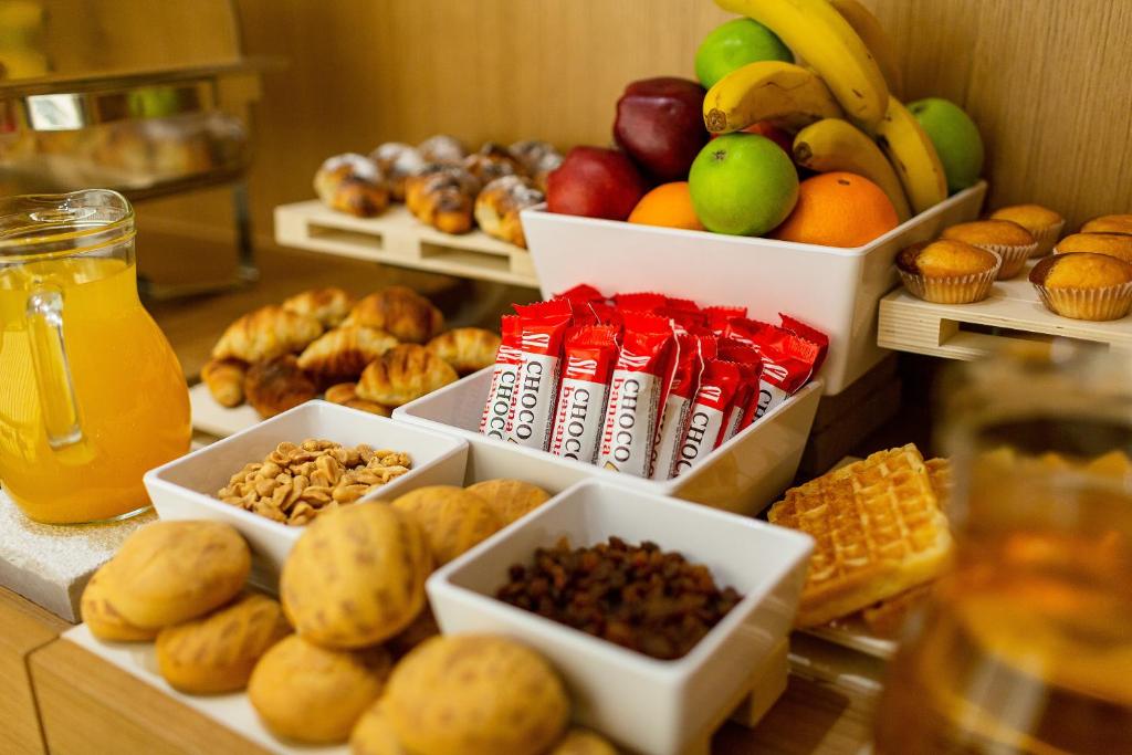 Bufete ar dažādiem brokastu produktiem, tostarp augļiem, kruasāniem, riekstiem, cepumiem un dzērieniem. Ideāla izvēle gardām un veselīgām brokastīm.
