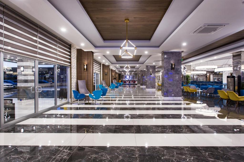 Mūsdienīga viesnīcas foajē ar elegantiem mēbeļu elementiem un stilīgu interjeru. Gaismas un tekstūra rada patīkamu atmosfēru.