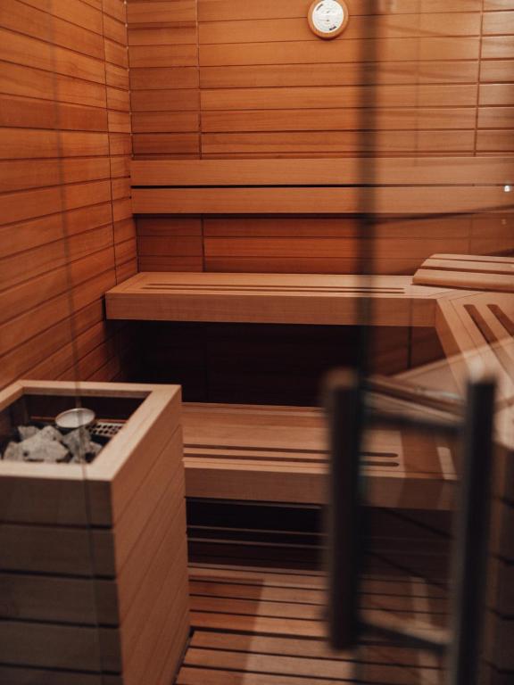 Koka sauna ar siltuma akmeni un mūsdienīgu interjeru, radot relaksējošu atmosfēru.