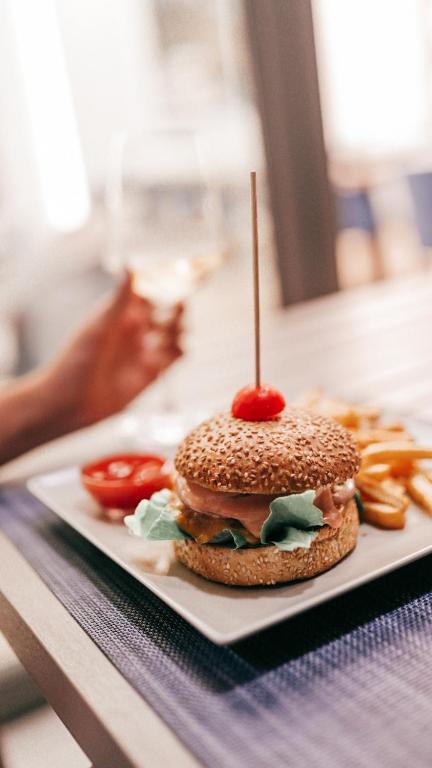 Gards burgers ar sezama maizi, zaļajiem salātiem un ķiršu tomātu, pasniegts ar frī kartupeļiem un kečupu. Ideāls ēdiens komfortablai maltītei.