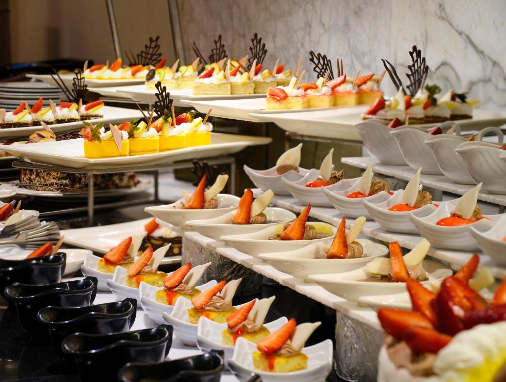 Kūku un desertu bufete ar dažādām gardām uzkodām, rotātām ar svaigām ogām un šokolādes dekoriem. Pievilcīgi pasniegti kārumi, kas iepriecina ar krāsām un prezentāciju.