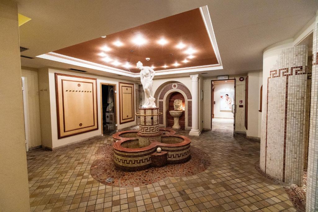 Elegants spa interjers ar centrālo strūklaku un greznām dekorācijām. Apgaismojums radījis relaksējošu atmosfēru, kas aicina uz atpūtu.