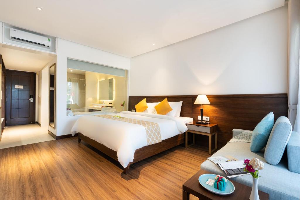 Mūsdienīgs viesnīcas numurs ar ērtu gultu, koka grīdu un gaišiem toņiem, kas rada mājīgu atmosfēru. Numurā ir dīvāns un naktsgaldiņš ar lampu.