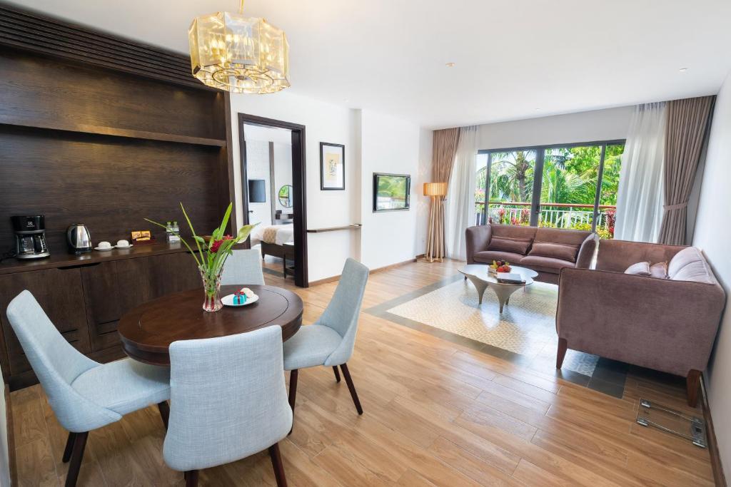 Mūsdienīgs viesnīcas numurs ar ērtu viesistabu, elegantu galdu un krēslus, kā arī lieliem logiem, kas sniedz skatu uz dārzu. Interjers ir gaišs un gaumīgs, radot mājīgu atmosfēru.