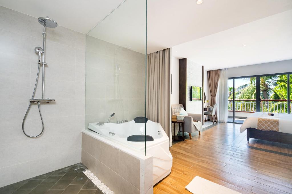 Mūsdienīgs viesnīcas numurs ar stikla dušu un burbuļvannu, kas piedāvā lielisku skatu uz dabu. Interjers ir gaišs un elegants, ar koka grīdu un komfortablām mēbelēm.