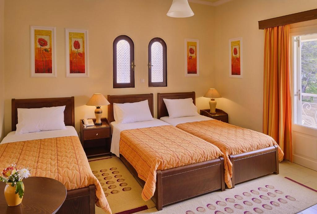 Skaisti ērta viesnīcas numurs ar trim gultām, apgaismotām galdiņiem un krāsainiem mākslas darbiem uz sienām. Gaismas un siltas krāsas rada patīkamu atmosfēru.