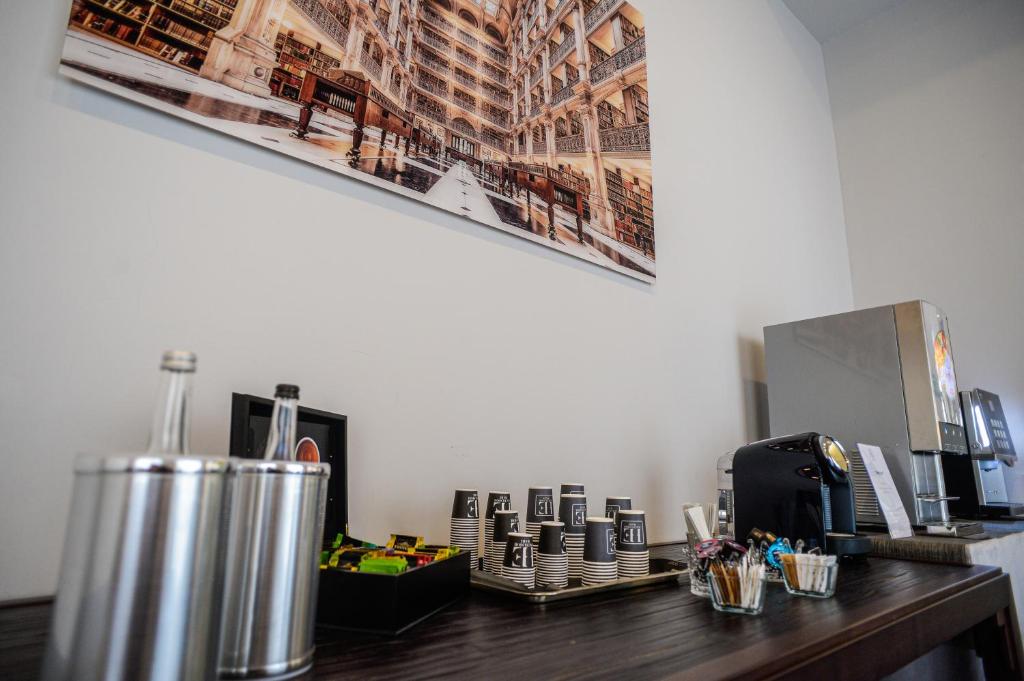 Kafijas stūrītis ar dažādiem dzērieniem un uzkodām, fons ar lielu bibliotēku attēlu.