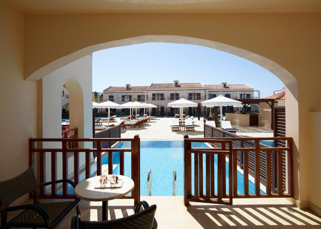 Eleganta viesnīcas terase ar skatu uz peldbaseinu, saulessargi un atpūtas krēsli. Ideāla vieta atpūtai un relaksācijai.