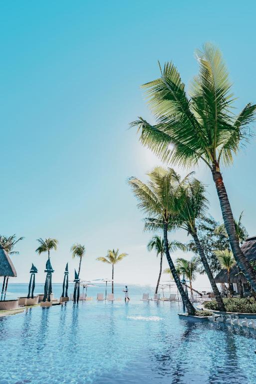 Tropu ainava ar palmām un nebeidzamu peldbaseinu, kas atspoguļo debesu zilumu. Ideāla vieta atpūtai un relaksācijai pludmalē.