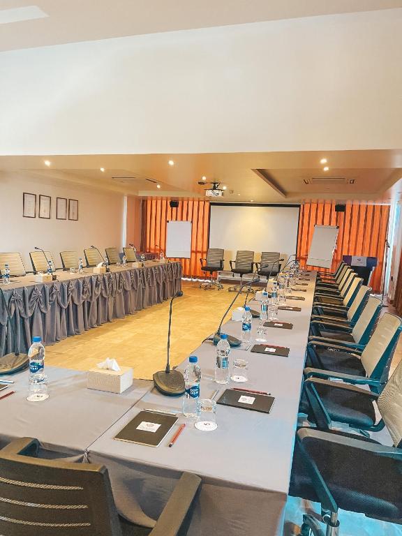 Konferencu zāle ar garu galdu, ap kuru ir ērtas krēsli, uz galda ir ūdens pudeles un rakstāmpiederumi. Zālē ir projekcijas ekrāns un flipcharts.