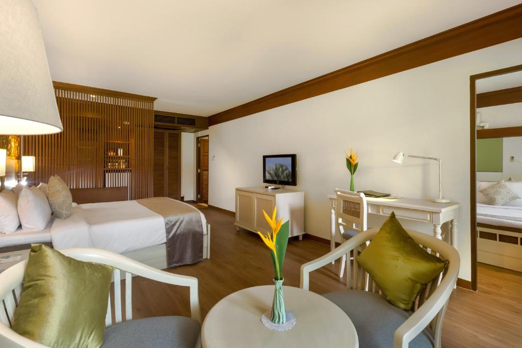 Mūsdienīgs viesnīcas numurs ar koka akcentiem, ērtām mēbelēm un ziedu kompozīciju uz galda. Numurā ir televizors un darba galds, radot patīkamu un relaksējošu atmosfēru.