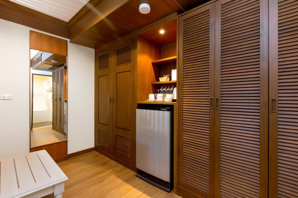 Mūsdienīga viesnīcas numura telpa ar koka apdari, spoguli un mini ledusskapi, kas piedāvā komfortu un ērtības. Izsmalcināts interjers ar slēgtām skapju durvīm un plauktiem.