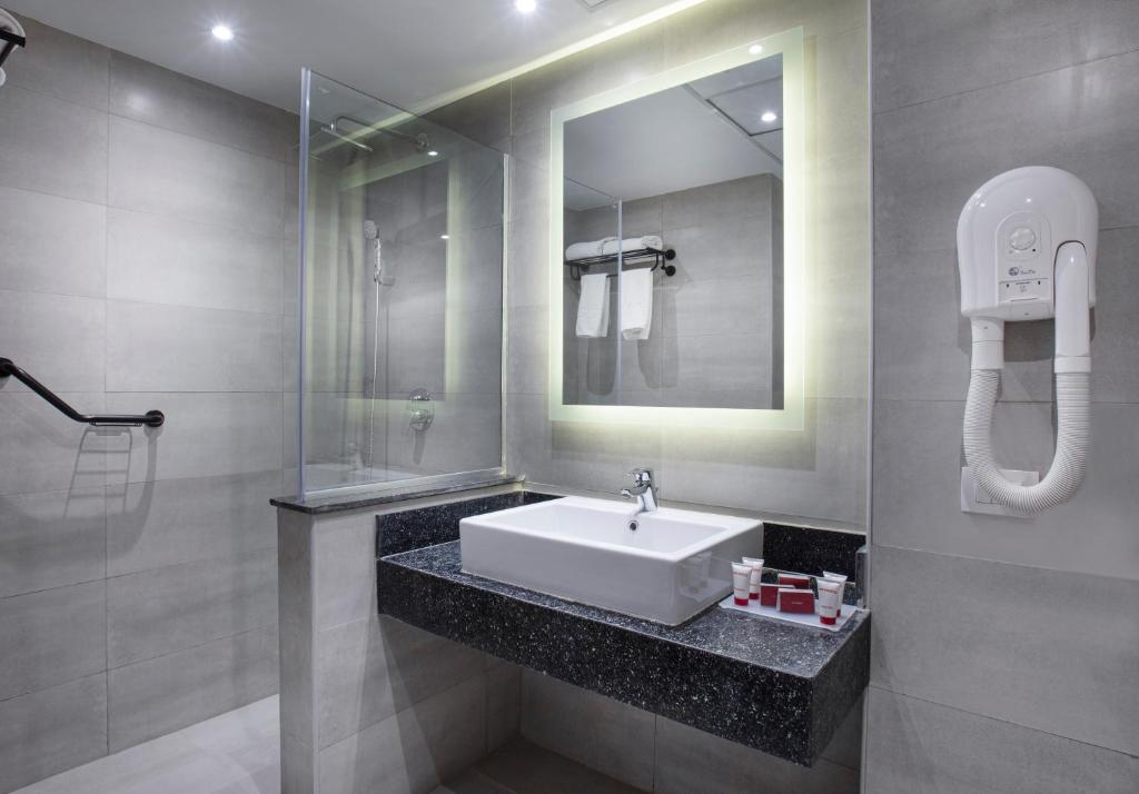 Mūsdienīga vannas istaba V Hotel Sharm El Shiekh ar spoguli un dušu.