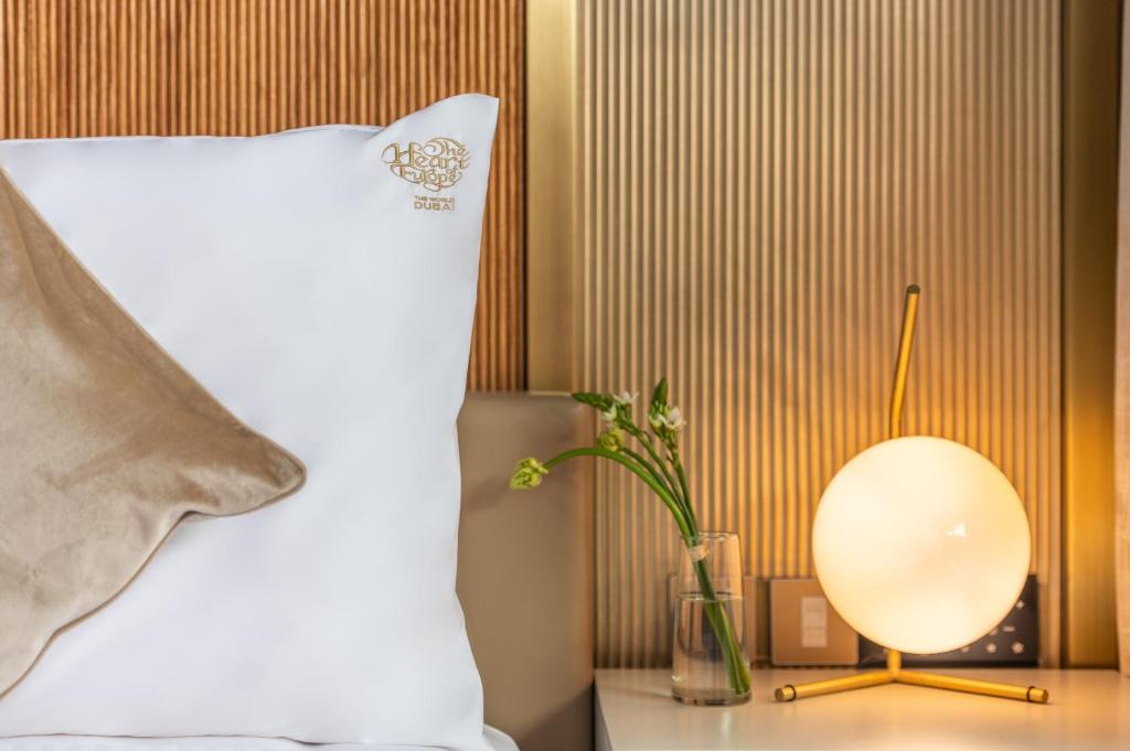 Elegants dizains Voco Monaco Dubai numurā ar spilvenu un lampu.
