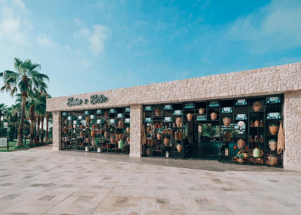 Selectum Family Resort Belek restorāns ar stikla fasādi un palmu kokiem