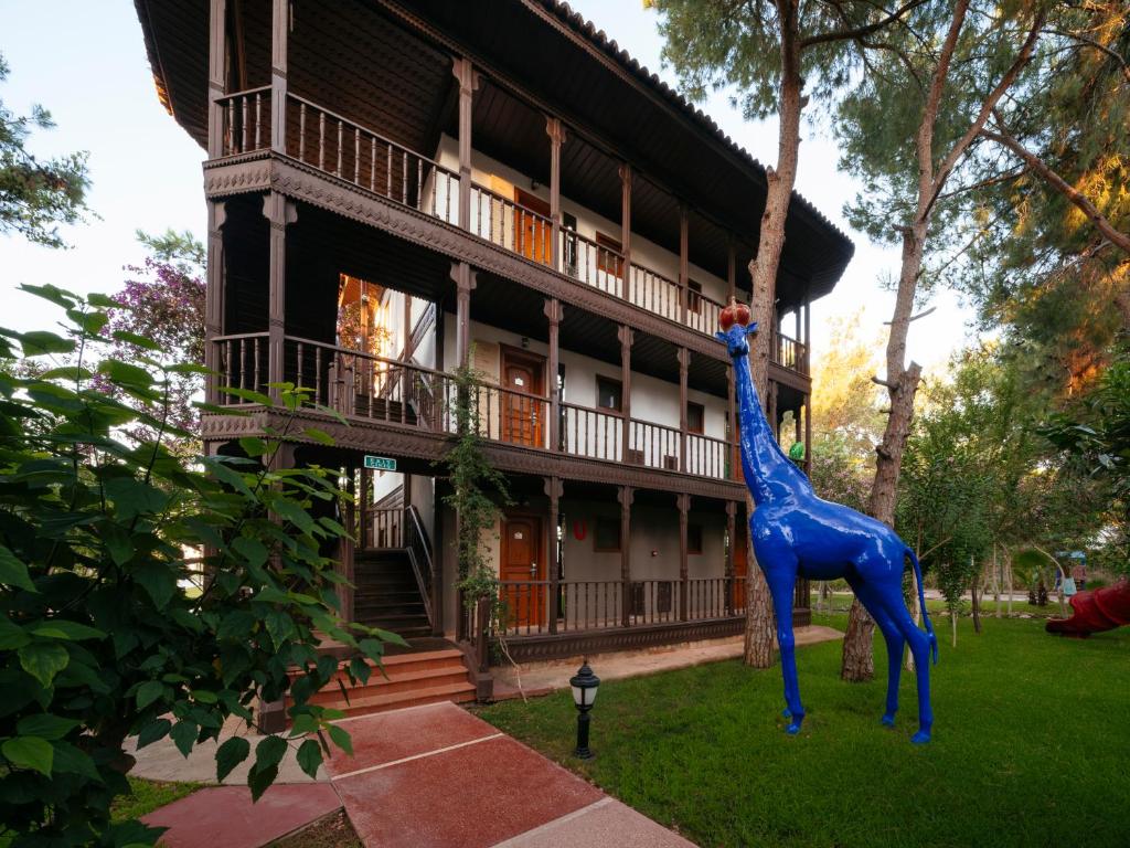 Selectum Family Resort Belek koka ēka ar zilu žirafes statuju priekšplānā